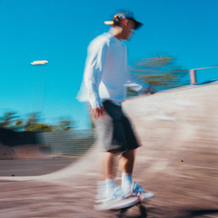 FROST mens white heavyweight longsleeve worn while skateboarding at UK skate park, motion blur shot capturing streetwear clothing in action