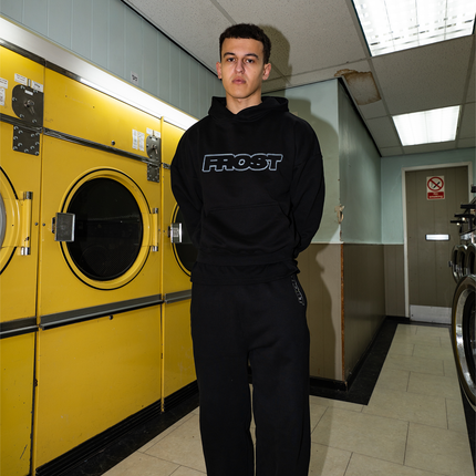 Black oversized boxy fit pullover hoodie named 'Chrome Logo Hoodie' featuring a metallic chrome inspired FROST logo print on the front. Made from 100% cotton, 500GSM heavyweight fabric, with a cropped & boxy fit.
